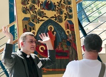 Ksiądz Dariusz  Klejnowski-Różycki oprowadza po wystawie ikon, która towarzyszyła konferencji.