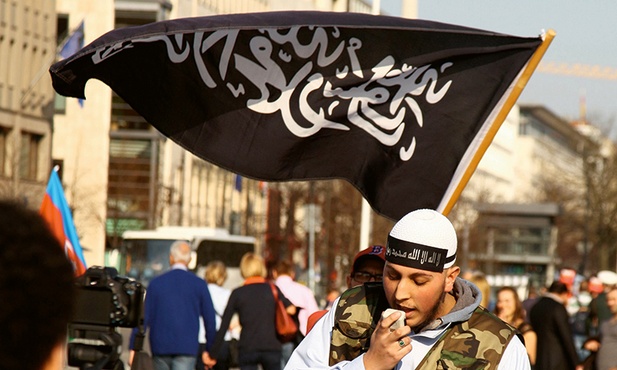 Członek salafickiej wspólnoty wzywa  do modlitwy i nawrócenia  w pobliżu Bramy Brandenburskiej w centrum Berlina.