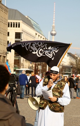 Członek salafickiej wspólnoty wzywa  do modlitwy i nawrócenia  w pobliżu Bramy Brandenburskiej w centrum Berlina.