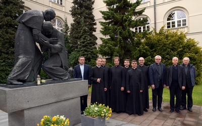 Wspólna fotografia nowych magistrów teologii z opiekunami ich prac przy pomniku św. Jana Pawła II i kard. Stefana Wyszyńskiego