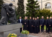 Wspólna fotografia nowych magistrów teologii z opiekunami ich prac przy pomniku św. Jana Pawła II i kard. Stefana Wyszyńskiego