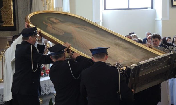 Strażacy wnoszą obraz Jezusa Miłosiernego do kościoła