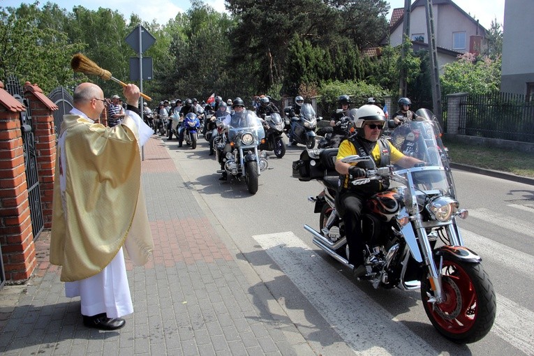 Ks. Adam Domański kropi wodą święconą przejeżdżających motocyklistów