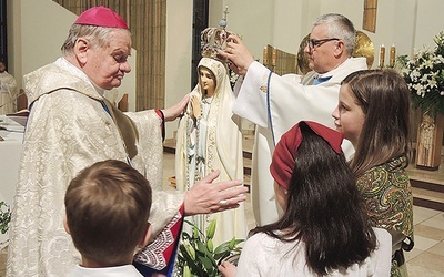 Bp Tadeusz Rakoczy w asyście ks. proboszcza Jerzego Musiałka nakłada koronę figurze Matki Bożej.