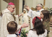 Bp Tadeusz Rakoczy w asyście ks. proboszcza Jerzego Musiałka nakłada koronę figurze Matki Bożej.