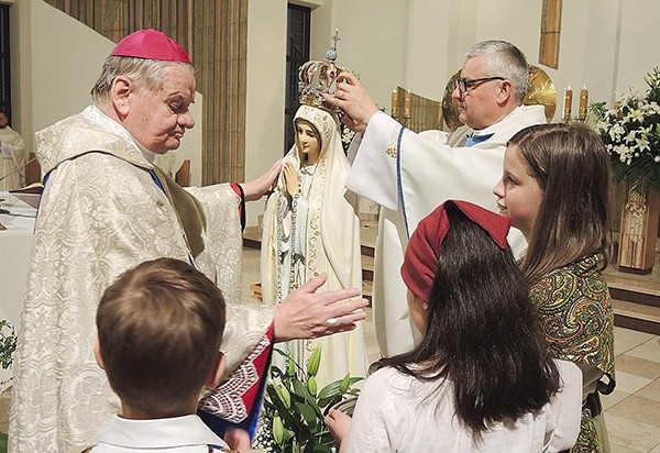 Bp Tadeusz Rakoczy w asyście ks. proboszcza Jerzego Musiałka nakłada koronę figurze Matki Bożej.