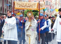 Abp Sławoj Leszek Głódź niesie Najświętszy Sakrament podczas procesji.