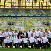 Pamiątkowe zdjęcie młodych piłkarzy z abp. Sławojem Leszkiem Głódziem na stadionie Energa