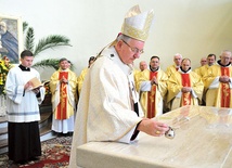 Arcybiskup Stanisław Budzik wylewa na ołtarz olej w celu namaszczenia.