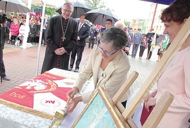 Danuta Ciesielska symbolicznie wbija gwóźdź w drzewce sztandaru szkoły.