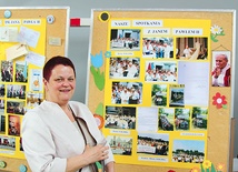 Dyrektor Anna Walusiak przy wystawie szkolnych zdjęć z patronem.