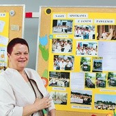 Dyrektor Anna Walusiak przy wystawie szkolnych zdjęć z patronem.