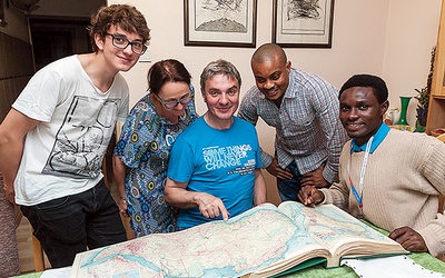 Rodzina państwa Gruców wraz z synem Marcinem i ich gośćmi z Nigerii oglądają mapę kraju w starym atlasie.