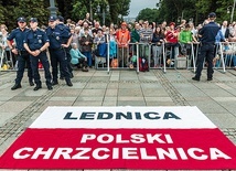 	Flaga Polski z zawołaniem lednickim została rozłożona tuż  przy figurze Matki Bożej. W tle pielgrzymi z diecezji gliwickiej.