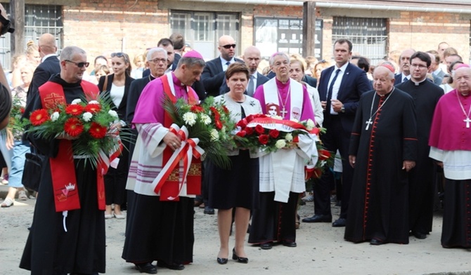 Bp Roman Pindel i premier Beata Szydło podczas złożenia kwiatów w miejscu placu apelowego, gdzie o. Kolbe zgłosił się na śmierć