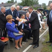 Włodarze gminy dzielili się chlebem z obecnymi na dożynkach. Z prawej wójt Marian Kmiecik