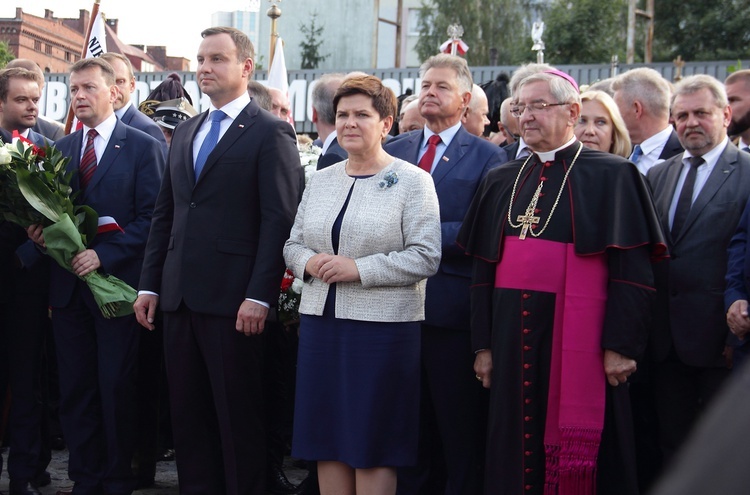 A. Duda i B. Szydło składają kwiaty pod bramą nr 2