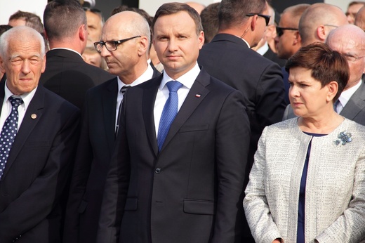A. Duda i B. Szydło składają kwiaty pod bramą nr 2
