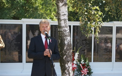 Krzysztof Jan Kaliński, burmistrz Łowicza, przed tablicami z nazwiskami pochowanych żołnierzy