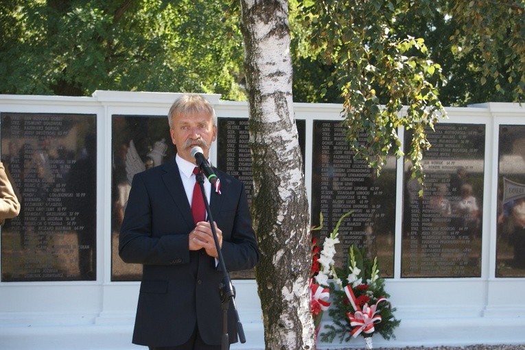Krzysztof Jan Kaliński, burmistrz Łowicza, przed tablicami z nazwiskami pochowanych żołnierzy