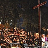 ▼	W grocie lurdzkiej  na Górze Świętej Anny, w rozświetlony płonącym ogniem wieczór, tysiące ludzi adorowały krzyż.