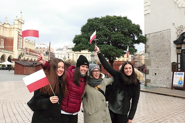 W marszu brali udział także goście z zagranicy. Na zdjęciu: grupa Włoszek pozuje na Rynku Głównym z chorągiewkami w polskich barwach narodowych.