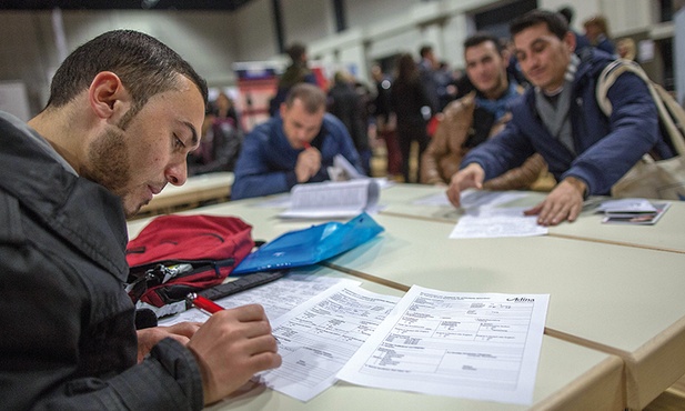 Uchodźca z Afganistanu wypełnia dokumenty  w biurze pracy w Berlinie. Państwo niemieckie coraz lepiej radzi sobie z opanowaniem fali uchodźców, społeczeństwo jednak nie ma już do rządzących zaufania.