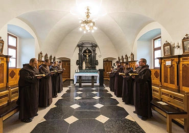 Karmelici odmawiają brewiarz w chórze  za ołtarzem.