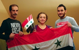 Od lewej: Nidal, Lena i Rafi w swoim opolskim mieszkaniu  z flagą Syrii.