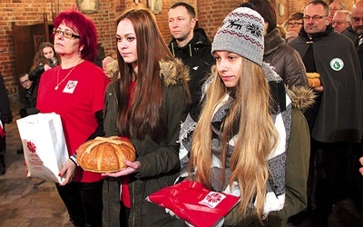 Osoby, które na co dzień pomagają potrzebującym, przyniosły w darach m.in. chleb, czapkę, szal i rękawiczki jako symbol pomocy niesionej osobom bezdomnym.