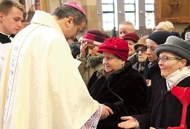 Biskup Tadeusz Lityński udziela sakramentu namaszczenia chorych, znaku czułego dotknięcia Boga.