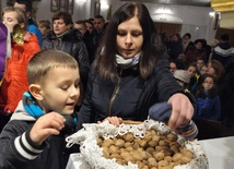 Uczestnicy liturgii zabierają pobłogosławione orzechy do domu