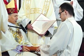 Daniel Kołodziejczyk przyjmuje od bp. Adama Pismo Święte.