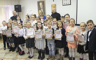 Młodzi laureaci konkursu z jego organizatorami. Od prawej: ks. Stanisław Łabendowicz, dyrektor Wydziału Katechetycznego, Ewa Majcher i ks. Sławomir Molendowski.