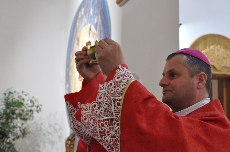 Biskup Leszkiewicz ukazuje dar kaganka, który ofiarowali młodzi w Szczawie 