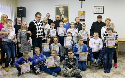 ▲	Laureaci z bp. Henrykiem Tomasikiem i organizatorami.