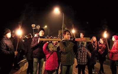 Młodzież i dzieci niosą krzyż podczas nabożeństwa ulicami dzielnicy Korabka w Łowiczu.