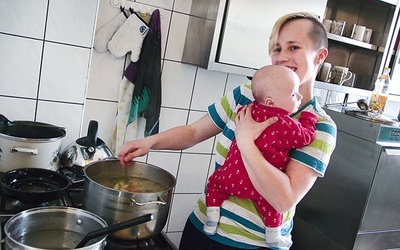 Dyżurująca w kuchni mama gotuje z synkiem na ramieniu. Trudne? Owszem, ale we własnym domu robiłaby dokładnie to samo.         