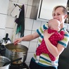 Dyżurująca w kuchni mama gotuje z synkiem na ramieniu. Trudne? Owszem, ale we własnym domu robiłaby dokładnie to samo.         