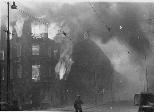 Fotografia z Raportu Stroopa. Płoną podpalone przez Niemców kamienice na skrzyżowaniu ulic Zamenhofa i Wołyńskiej