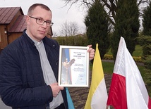 Ks. Mariusz Wilk z dyplomem potwierdzającym przyznanie nagrody wojewódzkiej.
