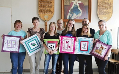 Uczestniczki nagrodzonego projektu „Współcześni Samarytanie” z opiekunami pod szkolną tablicą patronki św. Jadwigi i ich „Celinki”.