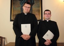 Neoprezbiterzy - ks. Rafał Woronowski (po lewej) i ks. Szymon Smółka z odebranymi dekretami