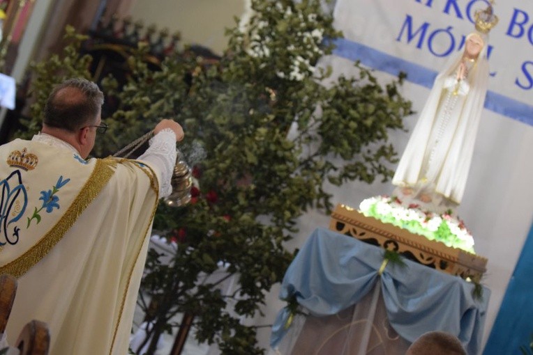 Proboszcz parafii, ks. Paweł Paździur okadza figurę Matki Bożej.