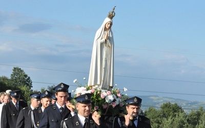 Strażacy niosący figurę Matki Bożej Fatimskiej