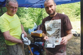 Andrzej Szelka i Radosław Zdaniewicz pokazują wydobyte z ziemi monety.