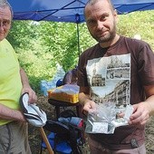 Andrzej Szelka i Radosław Zdaniewicz pokazują wydobyte z ziemi monety.