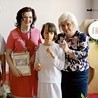 Kasia z rodzicami i panią katechetką po przyjęciu Pierwszej Komunii Świętej.