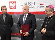 Wojewoda lubuski Władysław Dajczak przekazuje  bp. Tadeuszowi Lityńskiemu zarządzenie, które 7 września podpisała premier Beata Szydło.