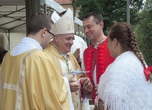 Na ręce bp. Piotra Gregera rodziny złożyły ofiarę na dzieła Caritas.